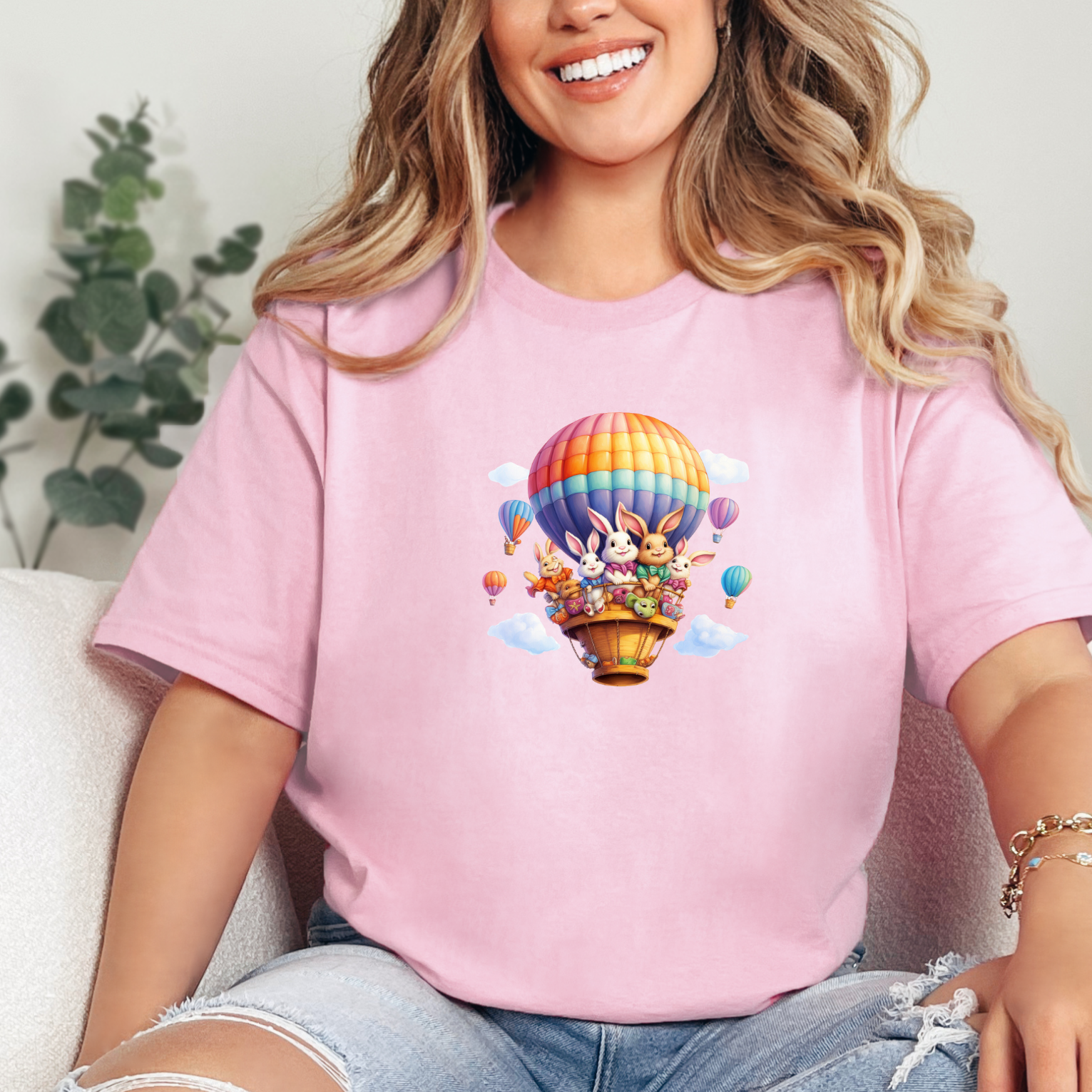 Graphic Unisex shirt of playful easter bunnies in a hot air balloon for easter on a Bella and Canvas shirt in the color light pink