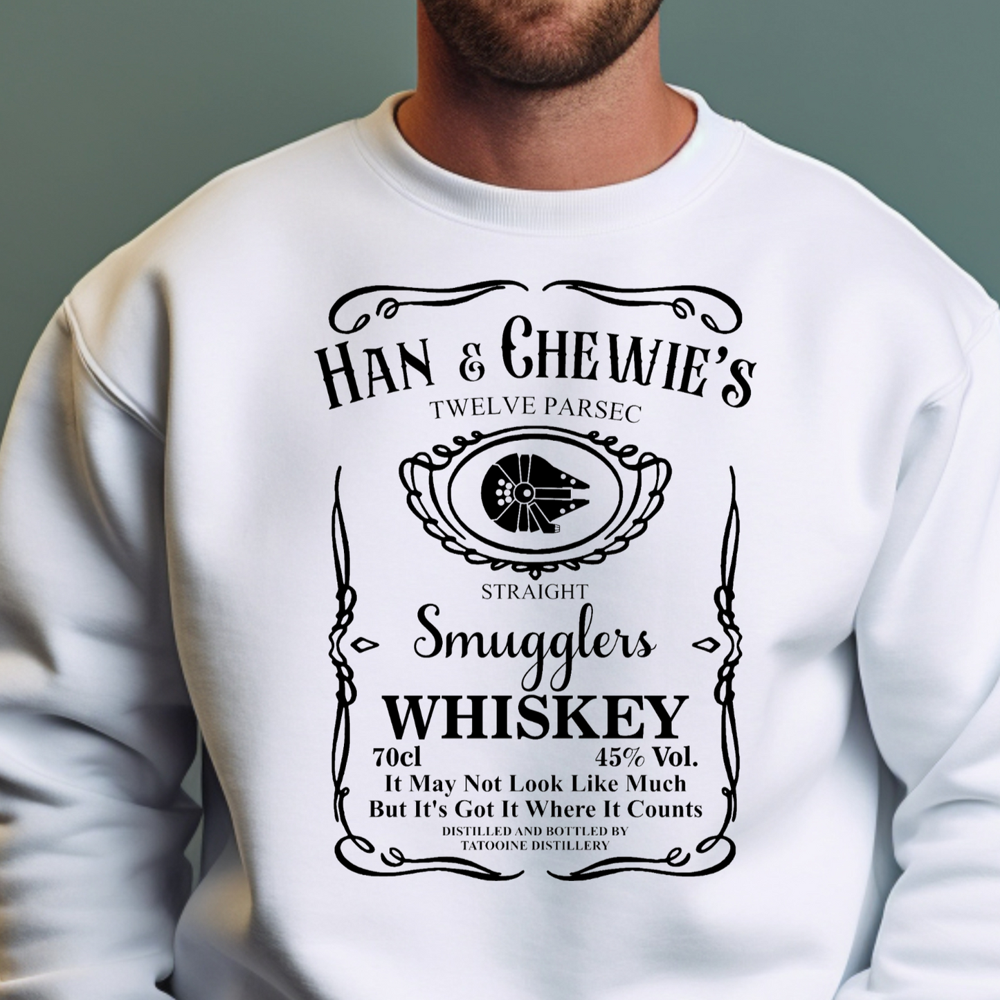 Graphic Unisex sweatshirt that displays that reads like a whiskey bottle "Han and Chewie's Smuggler Whiskey, Twelve Parsec Straight" and reads "It may not look like much but it's got a lot where it counts on Bella and Canvas 5000 sweatshirt in the color white