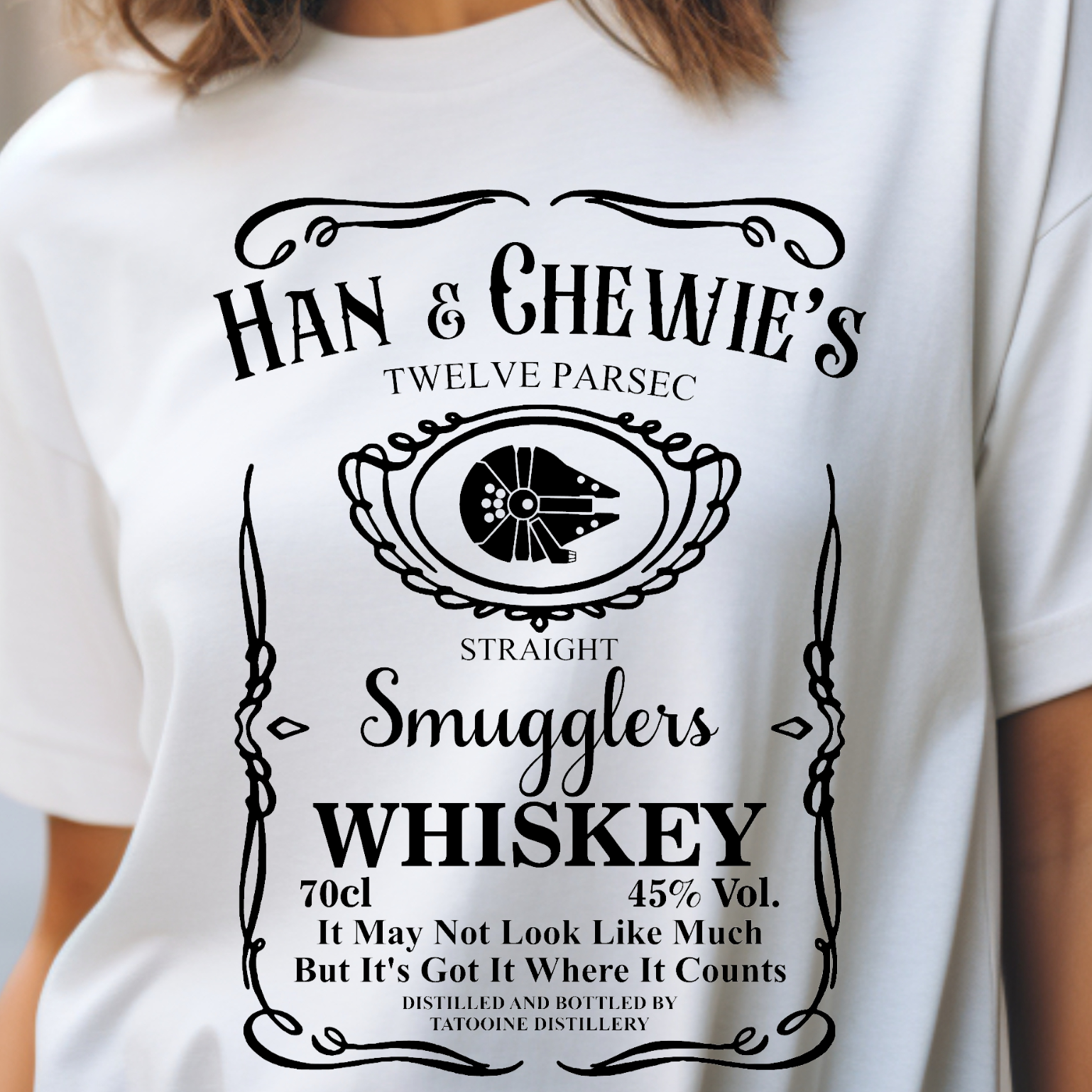 Graphic Unisex shirt that displays that reads like a whiskey bottle "Han and Chewie's Smuggler Whiskey, Twelve Parsec Straight" and reads "It may not look like much but it's got a lot where it counts on Bella and Canvas 5000 shirt in the color white